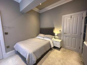 a small bedroom with a bed and a door at Stunning 2-bedroom Apartment in Manchester Centre in Manchester