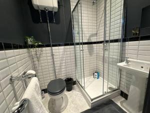 a bathroom with a shower and a toilet and a sink at Stunning 2-bedroom Apartment in Manchester Centre in Manchester