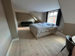 a bedroom with a bed and a large window at Byhuset - Penthouse in Vejle