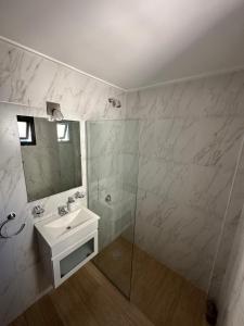 a white bathroom with a sink and a mirror at Departamento super luminoso - Zona 12 y 38 in La Plata