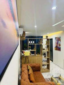 ein Wohnzimmer mit einer Couch und einem Bücherregal in der Unterkunft Appart haut standing Riviera in Abidjan