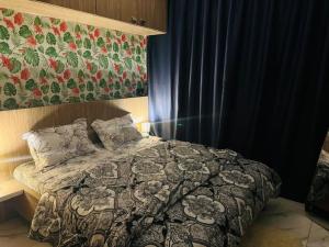 a bedroom with a bed with a comforter and a painting at Appart haut standing Riviera in Abidjan