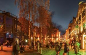 a group of people walking down a street at night at Temple bar - Entire 2 bedroom apartment in Dublin
