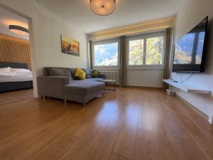 a living room with a couch and a flat screen tv at Center, Sauna, View - Haus LINARIA in Leukerbad