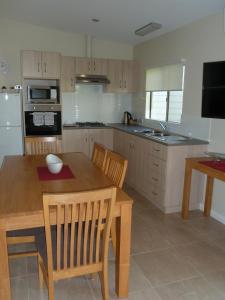 a kitchen with a wooden table and chairs and a kitchen with a refrigerator at Lilacs Waterfront Villas & Cottages in Albany