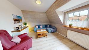 ein Wohnzimmer mit einer Couch und einem Tisch in der Unterkunft Ferienhaus Knippschild in Norderney