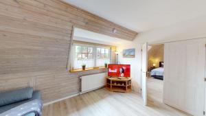 Zimmer mit einer Holzwand, einem TV und einem Bett in der Unterkunft Ferienhaus Knippschild in Norderney