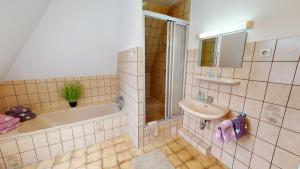 ein Badezimmer mit Badewanne, Waschbecken und Dusche in der Unterkunft Ferienhaus Knippschild in Norderney + 10 Fotos