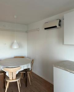 a table and chairs in a kitchen with a air conditioner at Villa Zöldvölgy - Lassulj le és töltődj fel nálunk in Szůcsi