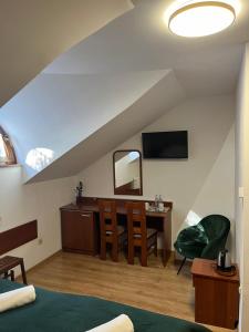 a bedroom with a bed and a desk with a mirror at Kamienica przy Bramie in Opatów