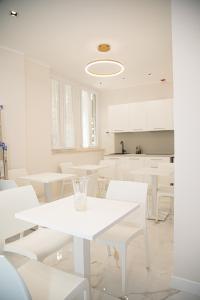 un comedor blanco con mesas blancas y sillas blancas en Roxy luxury house Rome, en Roma