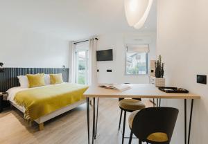 a bedroom with a bed and a table and chairs at Appart Hotel Neostelia in Annecy
