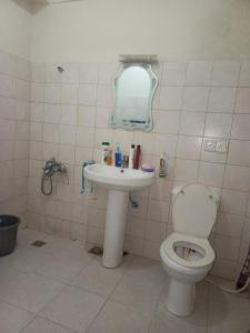 a bathroom with a toilet and a sink at A house where you feel like home in Islamabad