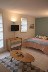 - une chambre avec un lit, une table et une télévision dans l'établissement Le 7 Augustin, à Nice