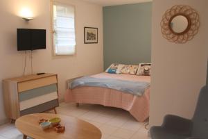 - une chambre avec un lit, une télévision et une table dans l'établissement Le 7 Augustin, à Nice