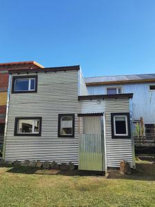 una pequeña casa con una puerta verde en un patio en Apart El Rosado, en El Chaltén