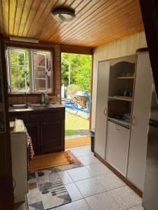 a kitchen with a sink and a refrigerator and a window at chalet chenal in Hauru +36 photos