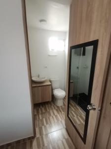 a bathroom with a toilet and a sink and a mirror at Apartamento Ibagué in Ibagué +27 photos