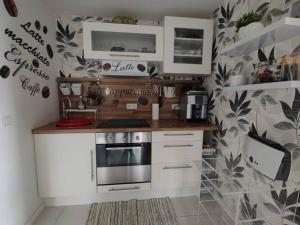 a kitchen with white cabinets and a stove at Ferienwohnung Zum Wäldchen in Haiger