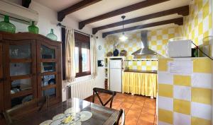 a kitchen with a table and a refrigerator at Casa Rural Los Olivos in Sotoserrano