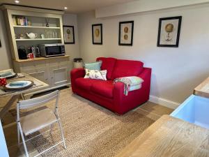 a red couch sitting in a living room at The Cottage at Yewtree Farmhouse in Newbury
