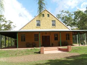 een huis met een gambrel dak en een veranda bij Back to the Bush in Aramara