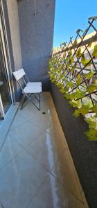 a white chair sitting on a balcony with a plant at Diar Kamiliya Meknès in Meknès