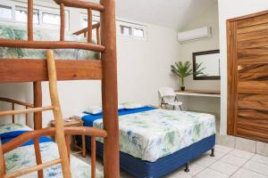 a bedroom with two bunk beds and a desk at Villa Mona Casa en la Playa in Taxisco