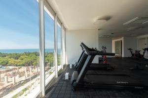 a gym with a treadmill and large windows at Apartamentos Luxury Hotel Porto Horizonte - AR Rentals in Gaira +14 photos