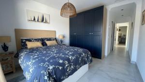 ein Schlafzimmer mit einem blauen und weißen Bett und einem Flur in der Unterkunft Comino Penthouse in Cómpeta