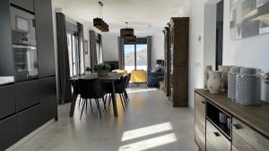 eine Küche und ein Esszimmer mit Tisch und Stühlen in der Unterkunft Comino Penthouse in Cómpeta