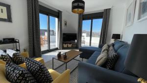 ein Wohnzimmer mit einem blauen Sofa und einem Fernseher in der Unterkunft Comino Penthouse in Cómpeta