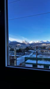 a window with a view of snow covered mountains at Robinson Alojamientos - Edificio María Gricelda in Ushuaia