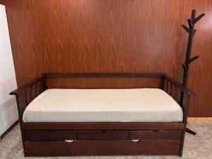 a bed in a room with a wooden wall at Descanso Río Grande in Río Grande