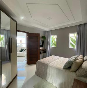 une chambre avec un lit avec des oreillers dessus dans l'établissement Casa completa em Natal! - Conforto e elegância para suas férias, à Natal