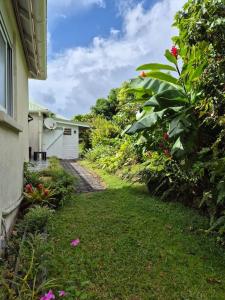 un patio con una casa y un jardín con flores en Gîte Ti jit la, en Saint-Claude