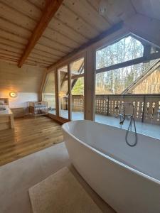 a bath tub in a room with a large window at Gorjuška Rozamunda in Bohinjska Bistrica
