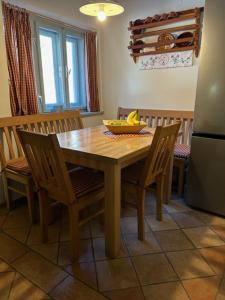 a wooden table with chairs and a bowl of bananas on it at Gorjuška Rozamunda in Bohinjska Bistrica +12 photos