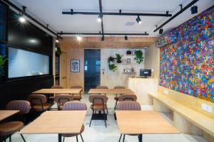 a restaurant with tables and chairs and a colorful wall at MEO! Hostel in São Paulo