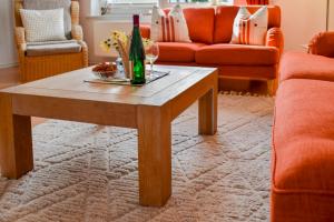 a living room with a table with a bottle of wine at Ferienhaus Fiete XXL auf Rügen - Doppelferienhaus für 16 Personen in Sagard