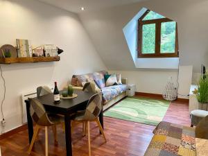 a living room with a table and a couch at CALMFRANC ático abuhardillado con vistas al río y la montaña Avistamiento de ciervos en Canfranc Pueblo in Canfranc
