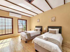 two beds in a room with two windows at Newly renovated, City Central, Spacious and Family friendly in Cape Town