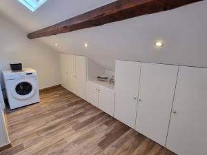 a kitchen with white cabinets and a washing machine at Elégance Provinoise aux pieds des remparts Classé in Provins