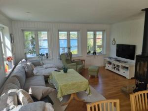 a living room with a couch and a tv at Stort landsted med egen strand in Rød