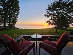 Un patio con dos sillas y una mesa con una puesta de sol. en Wisconsin Lake Escape, en Racine