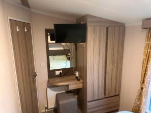 a room with a desk with a mirror and a television at 3BR-Sleeps6-Parking-Pool-NearBeach&Skegness in Skegness