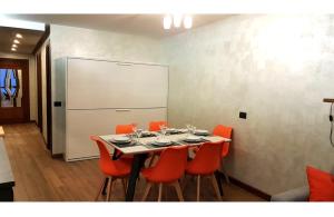 jadalnia ze stołem z pomarańczowymi krzesłami i tablicą w obiekcie Orange Fox Cervinia apartment Vda Vacanze in Vetta CIR 0185 w mieście Breuil-Cervinia +36 zdjęć