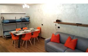 Pokój z kanapą i stołem z pomarańczowymi krzesłami w obiekcie Orange Fox Cervinia apartment Vda Vacanze in Vetta CIR 0185 w mieście Breuil-Cervinia