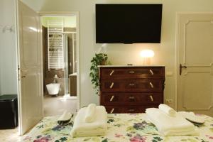 a bedroom with a bed with a dresser and a television at Vivi Lucca con "Madame Fannj" - Camera Verde in Lucca