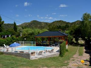 a swimming pool with a gazebo next to at Cabañas Sol Dorado in Potrero de los Funes